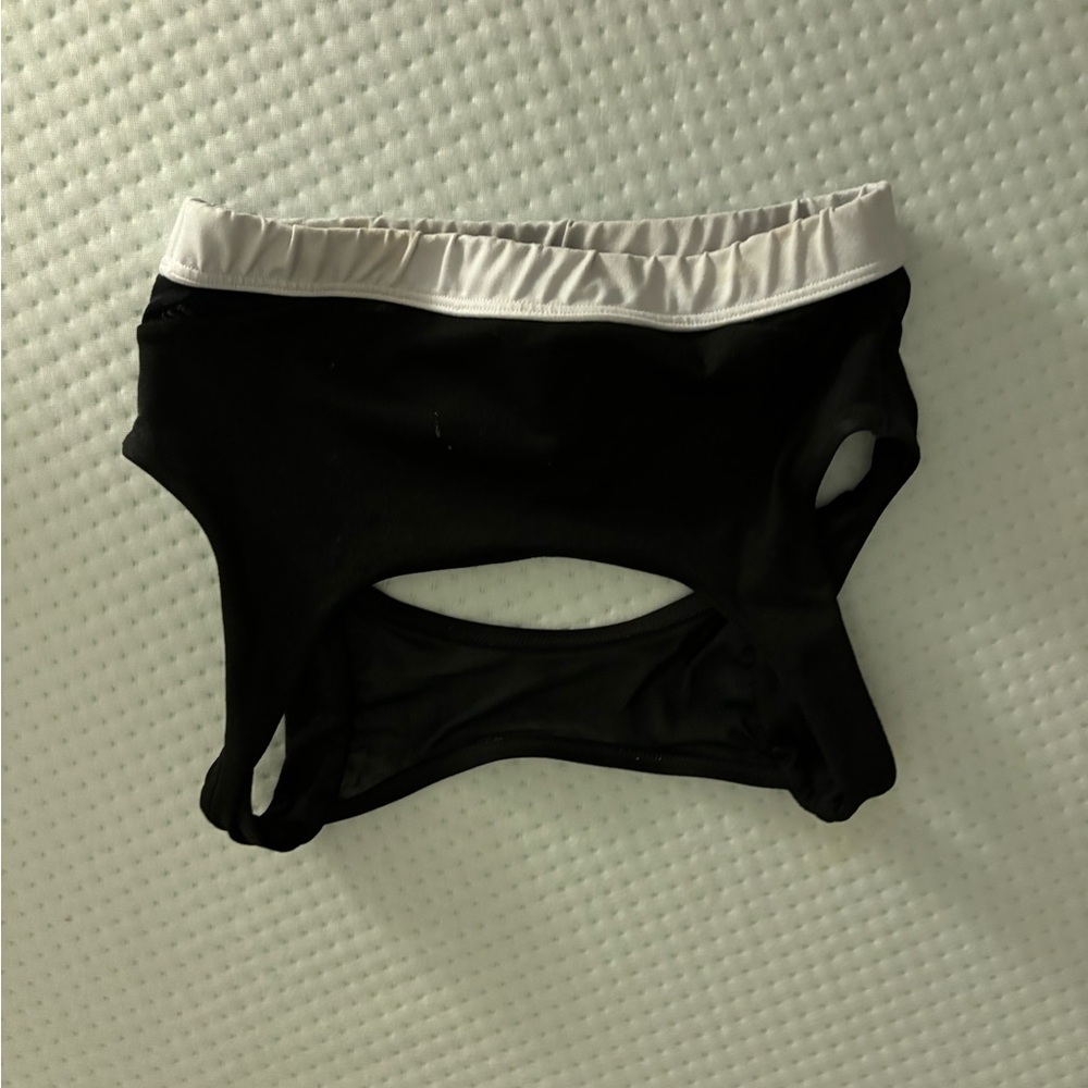Black sports bra with a white band and an open back